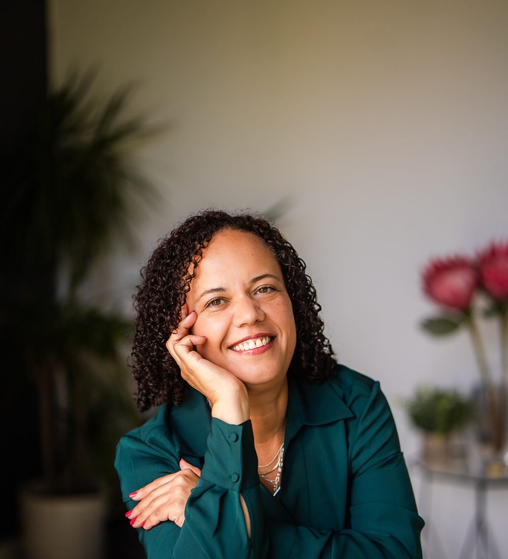 Alicia Noble, smiling, resting her chin on her hand