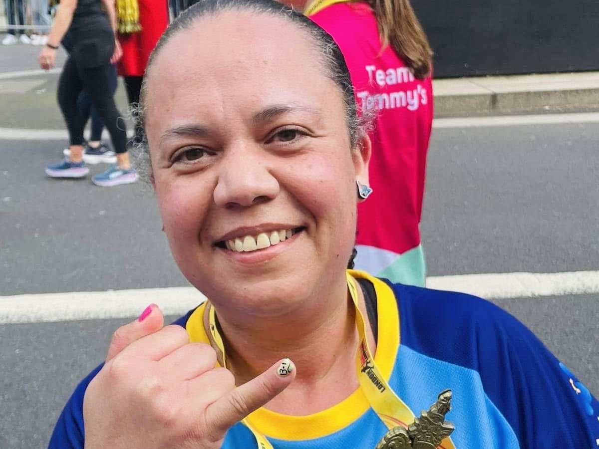 Alicia smiling after a charity run, holding up her medal