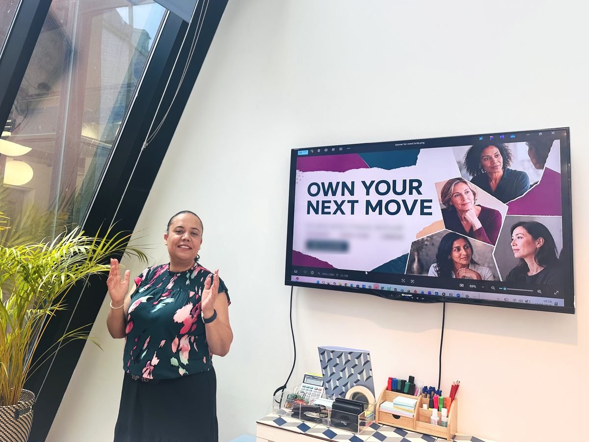 Alicia Noble smiling as she presents at an Own Your Next Move workshop, with the workshop title on the screen beside her
